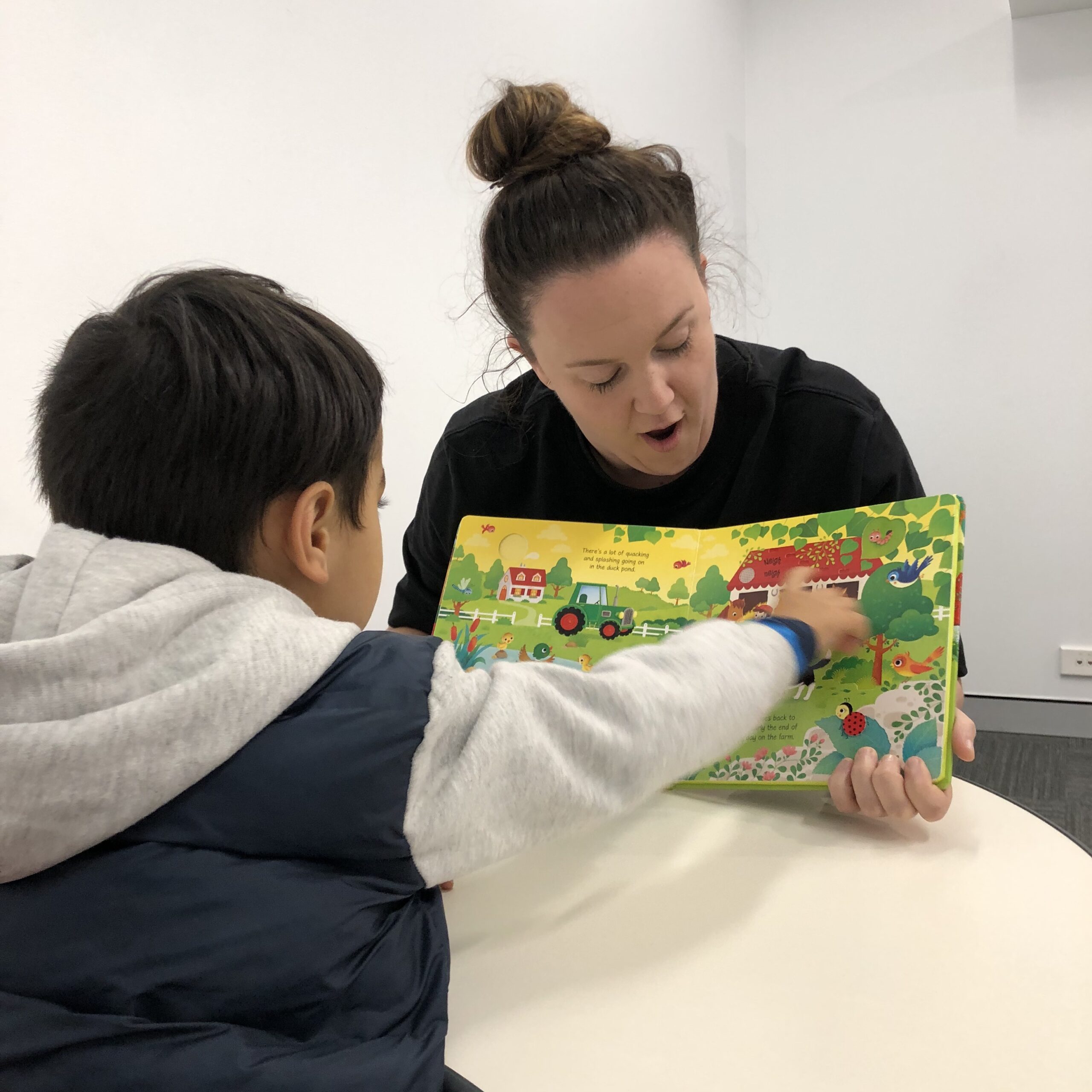 Toddler reading a book to work on speech and language delay with our Speech Pathologist in Bondi Junction and Mascot.