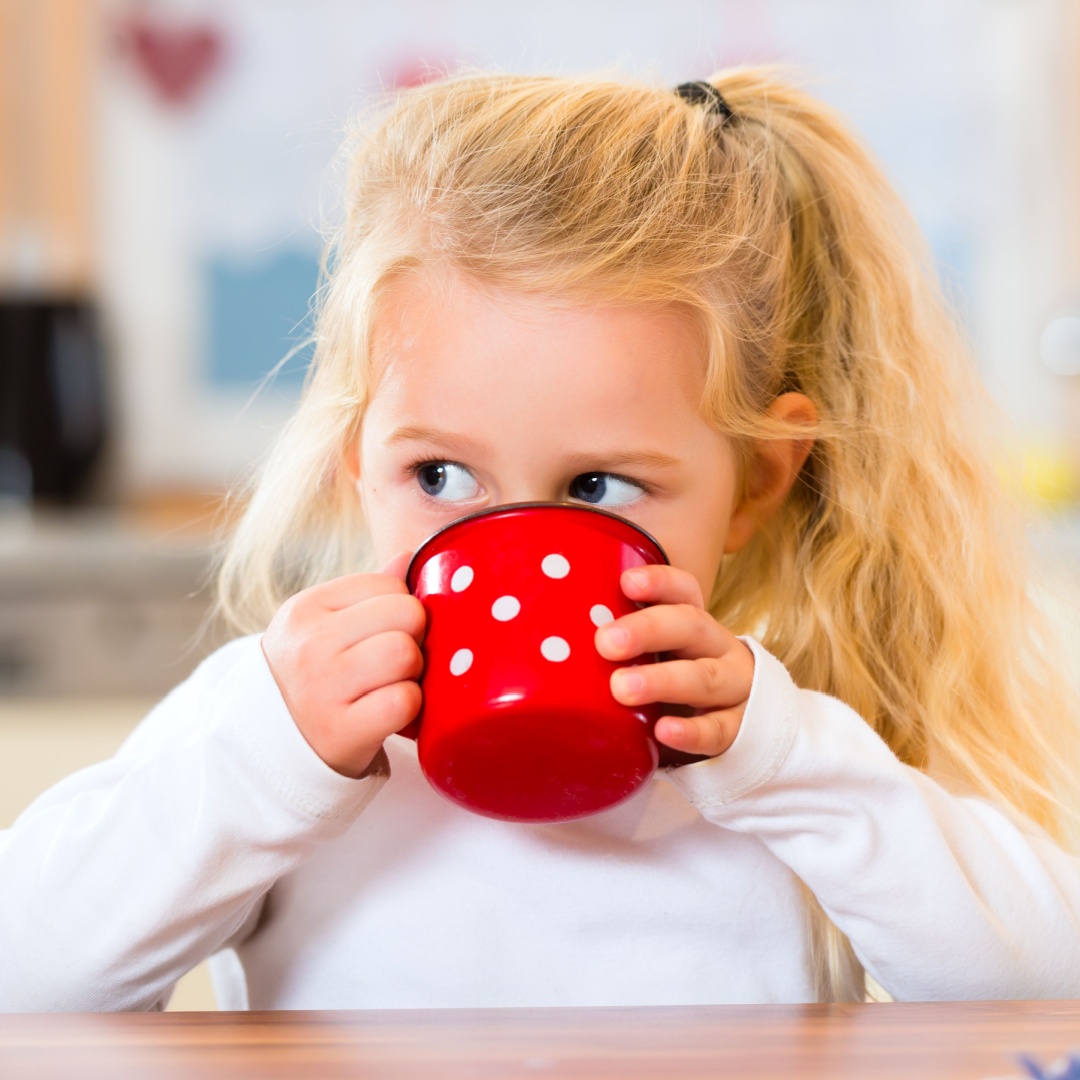 Young girl learning to drink from a cup with an occupational therapist in clinics in Bondi Junction and Mascot.