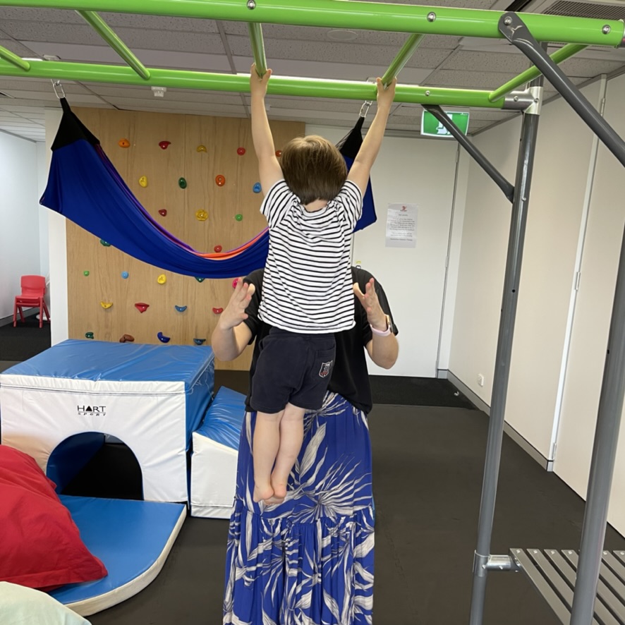 A young bpy working on his postural stability with an occupational therapist in our occupational therapy clinic in bondi junction and mascot